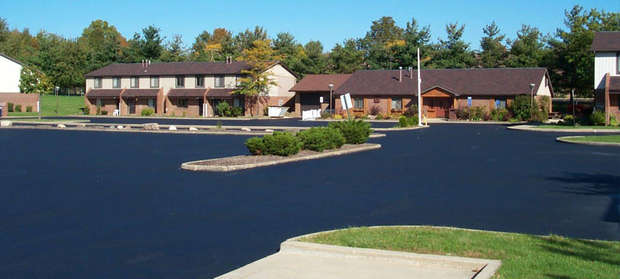A resurfaced asphalt parking lot looks fresh and clean.