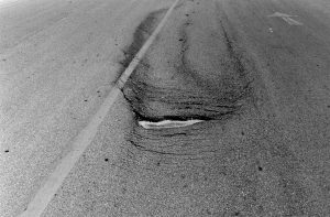 Slippage Cracking is crescent-shaped cracks in the surface layer of asphalt
